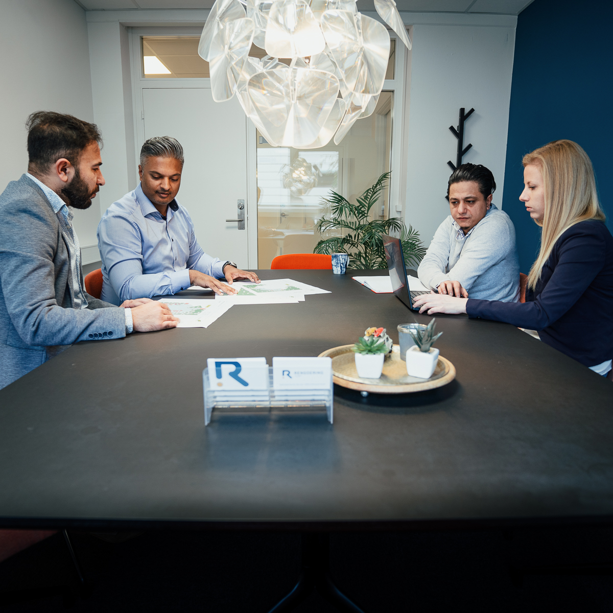 The Qash Labs operating team reviewing contract plans around a meeting table in Denmark